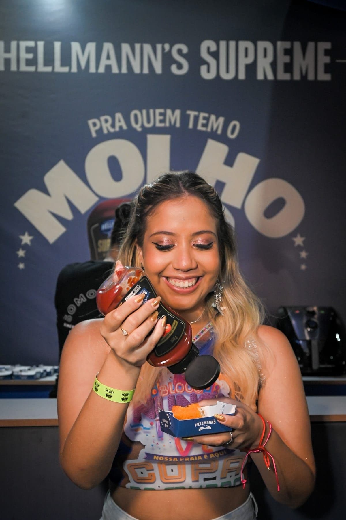 Convidada sorrindo com o brinde recebido na ativação